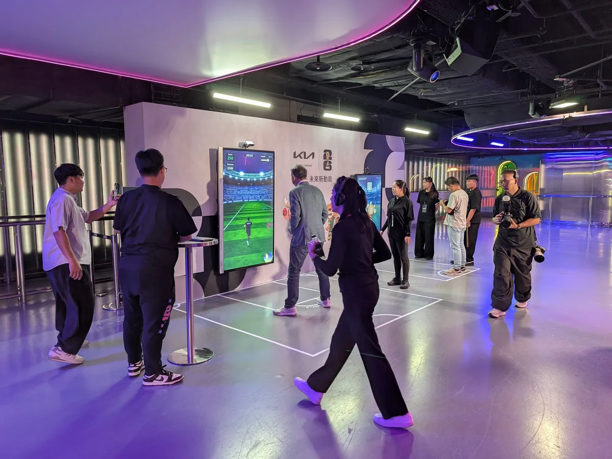 Guests play Kia Move Challenge at the media party while a photographer and other guests look on