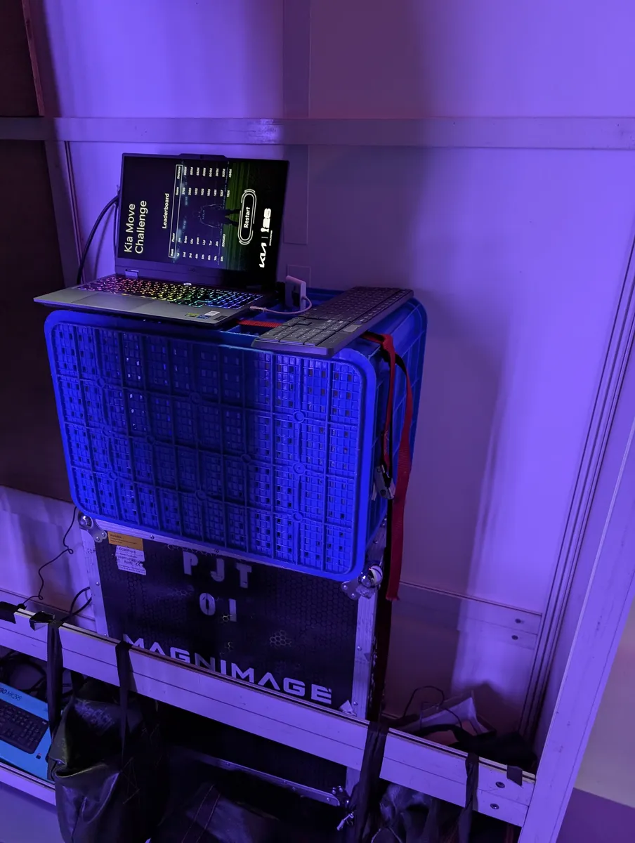 A laptop on a flight case behind the wall, showing the game
