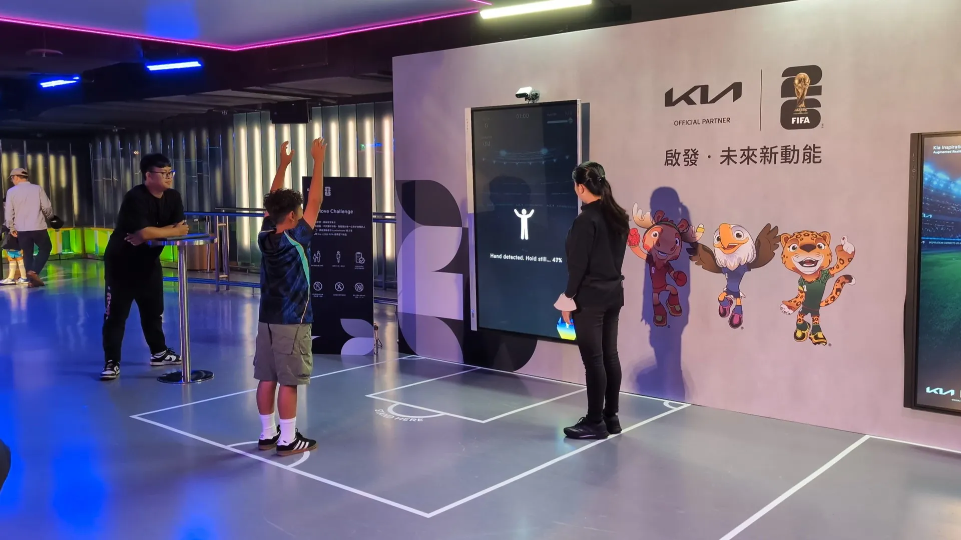 A player raises both arms in front of the screen while the game finds him