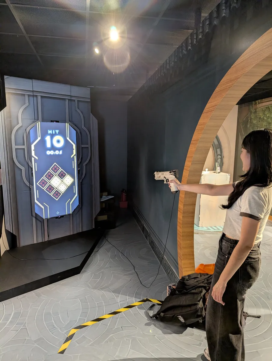 A visitor aims at the lit targets with ten hits on the counter