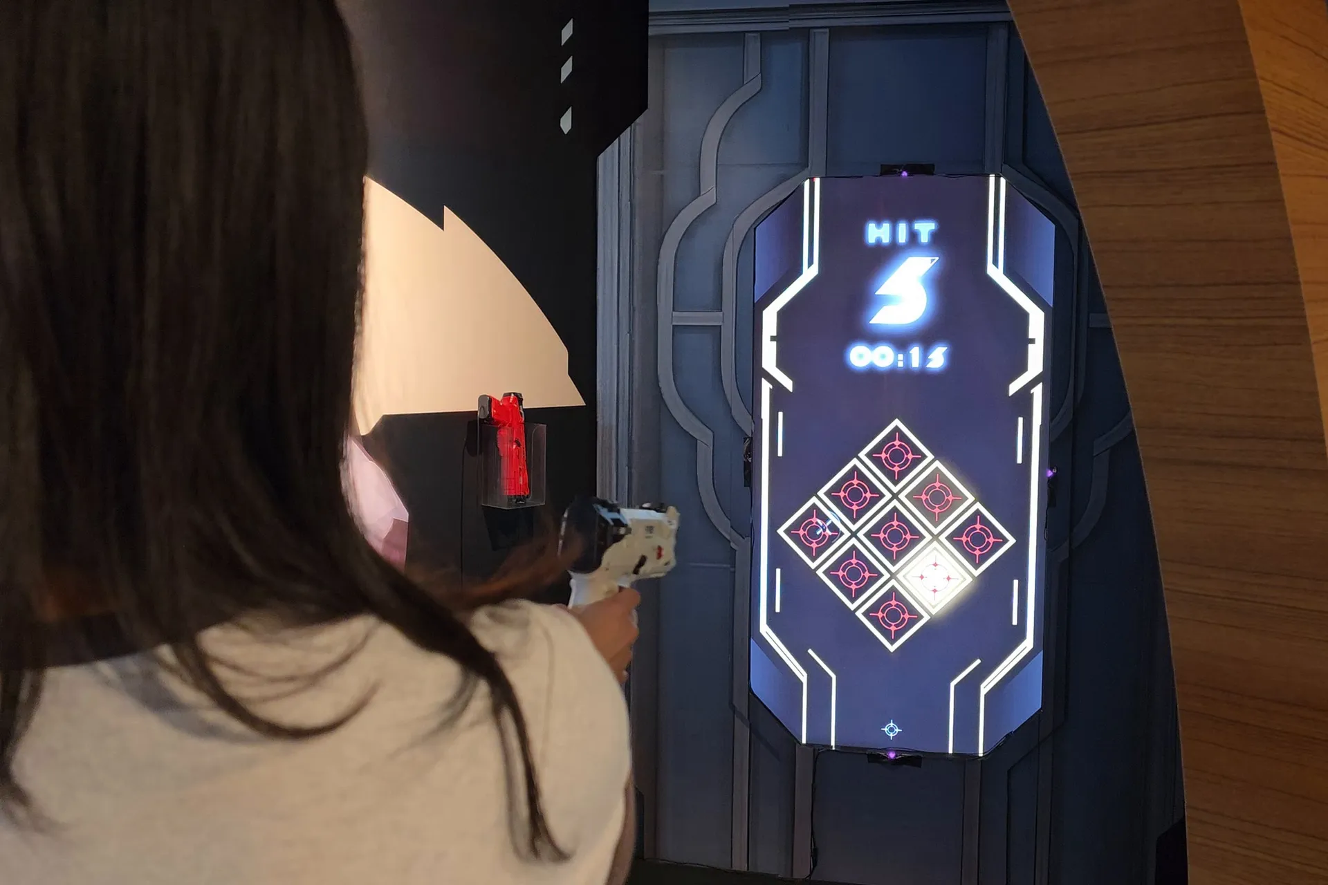 Over a player’s shoulder: the light gun aimed at the nine targets, five hits and fifteen seconds left