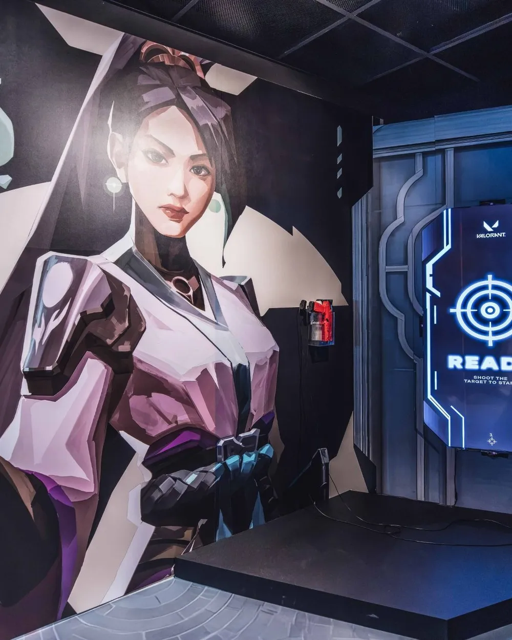 The game screen showing READY, set into the scenic wall beside a mural of a VALORANT agent
